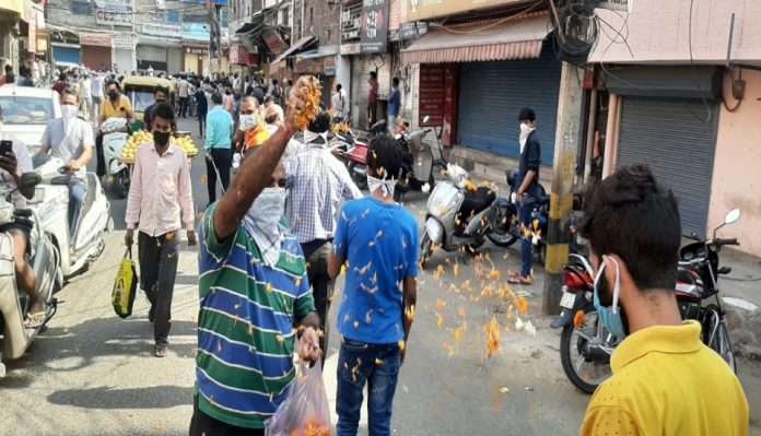delhi man showers flower petals on people standing in queue outside liquor shops viral video on social media